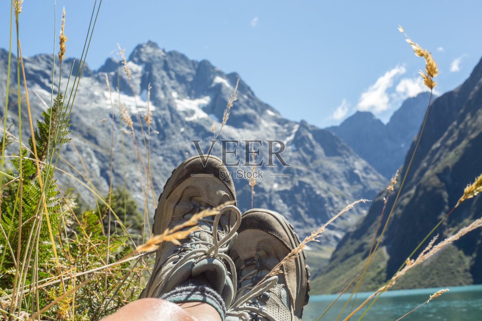 在玛 Marian 湖的岩石上,女士的腿和登山靴照片摄影图片