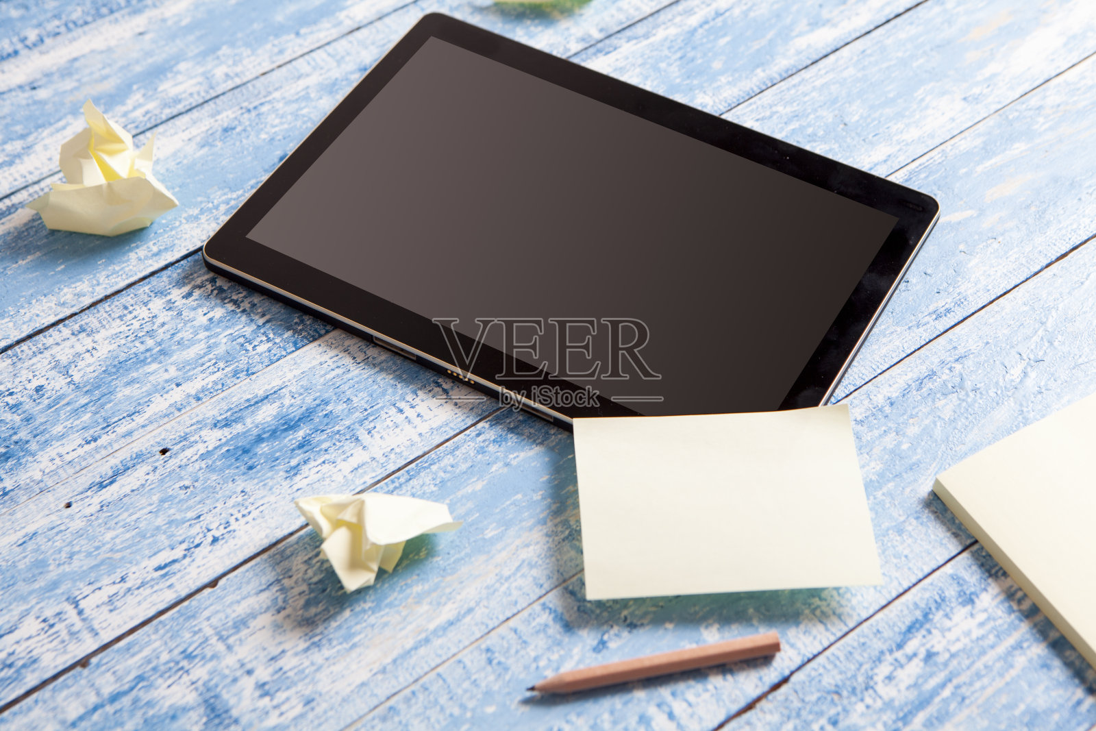 数字平板电脑和便利贴在旧木头上照片摄影图片