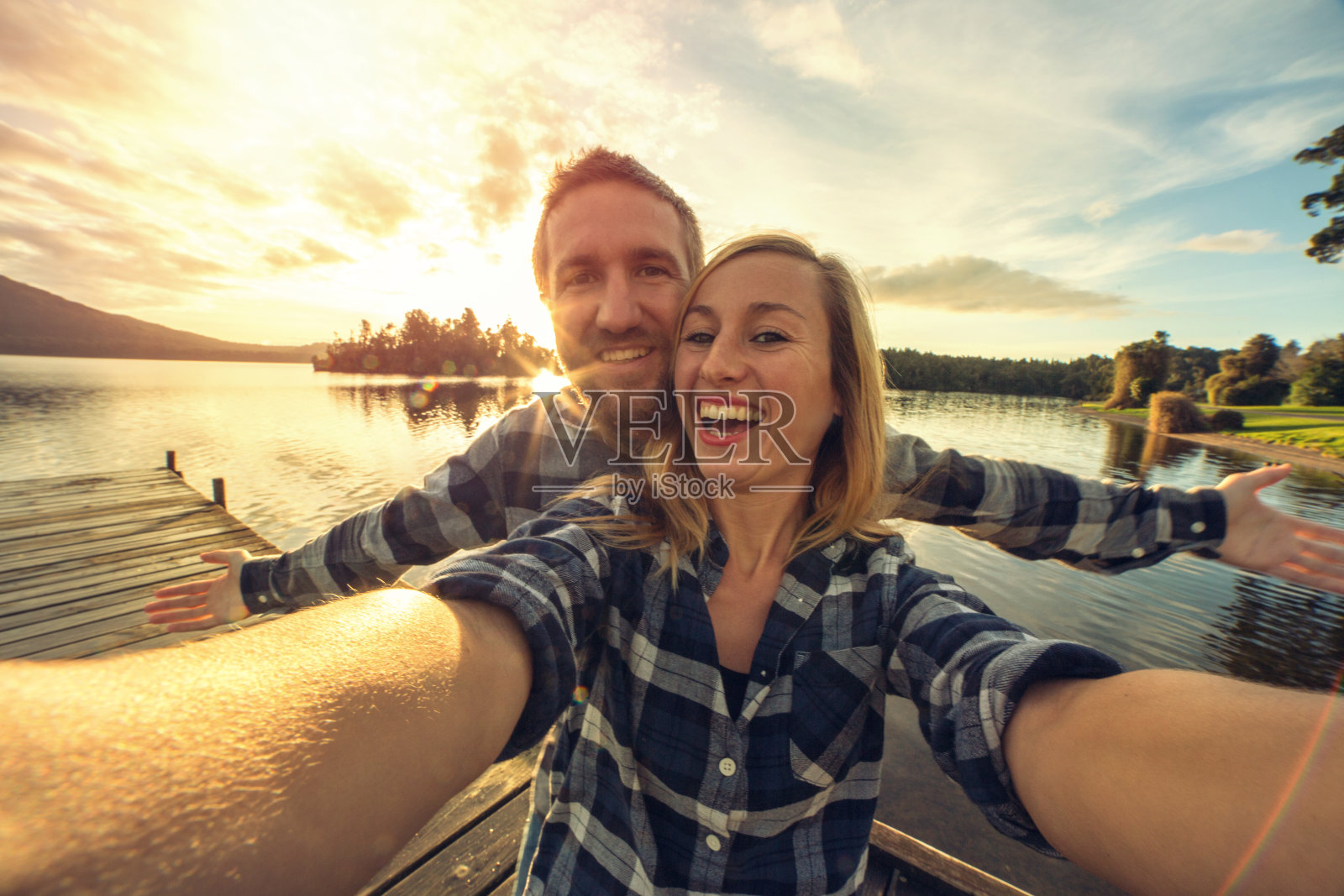 年轻情侣在湖边码头自拍照片摄影图片