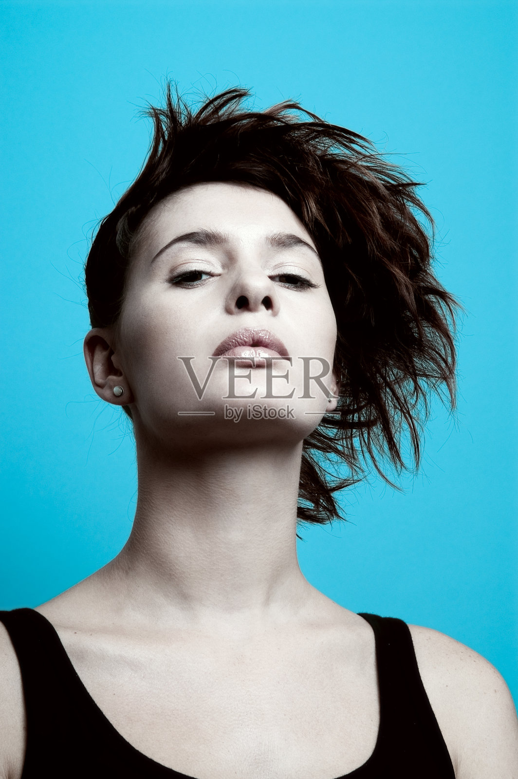 年轻女子与时尚的发型在蓝色的背景照片摄影图片