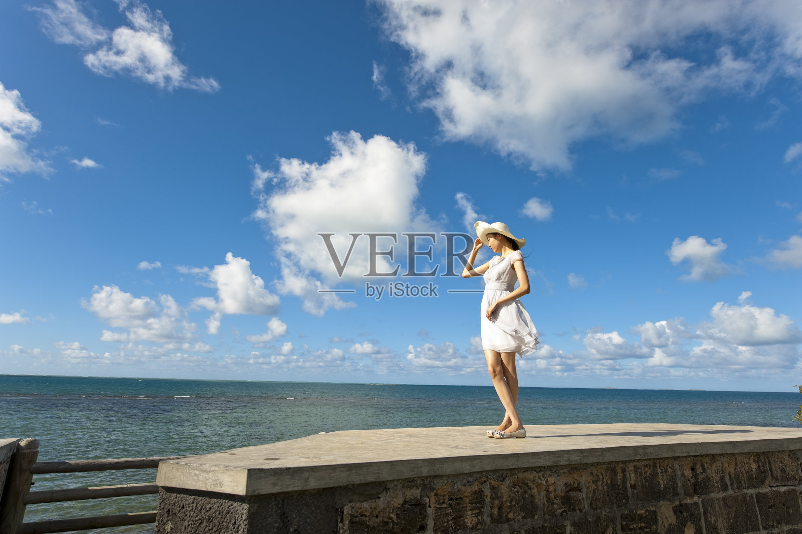 年轻女子站在海边照片摄影图片