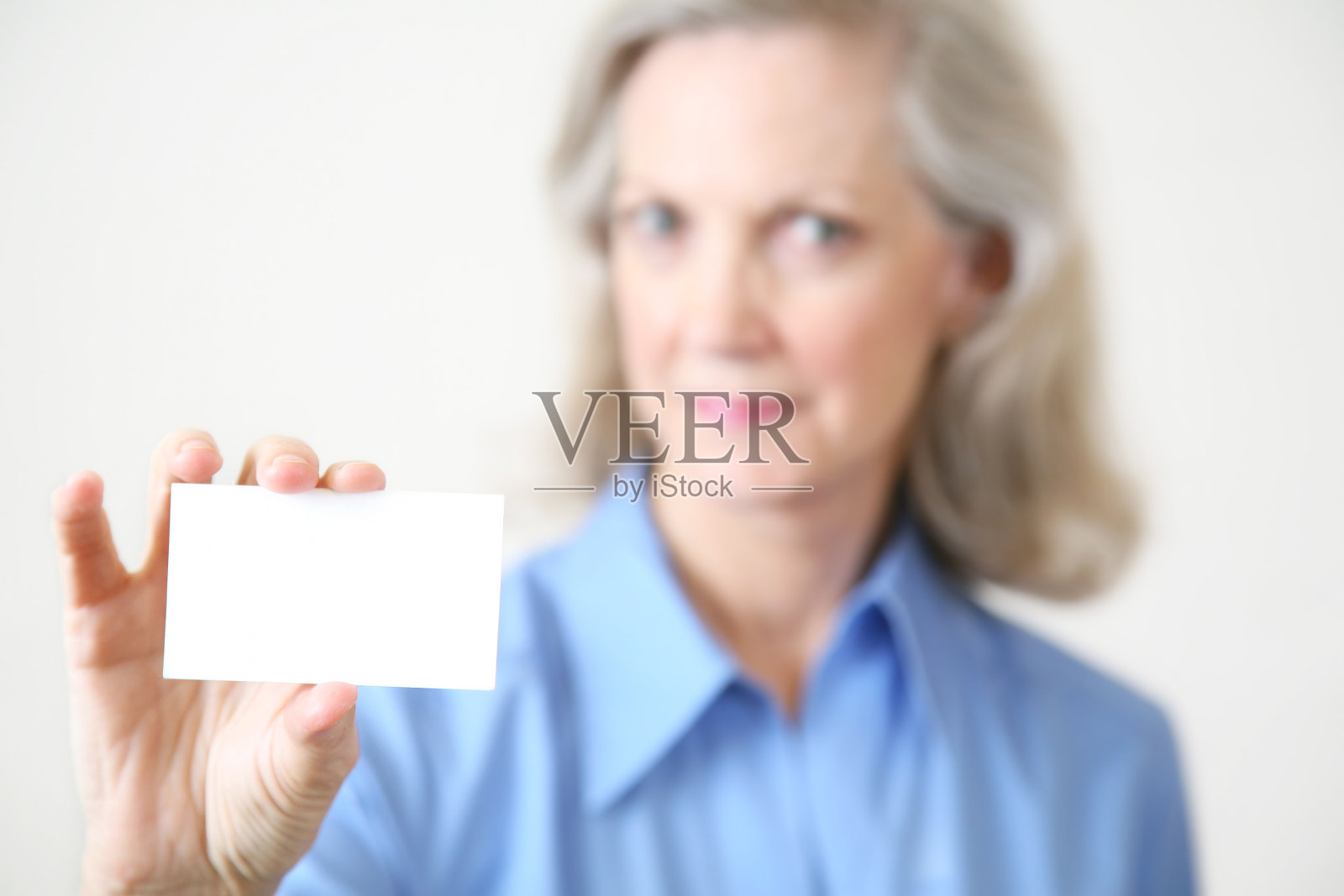 成熟的女商人拿着一张空白的名片照片摄影图片