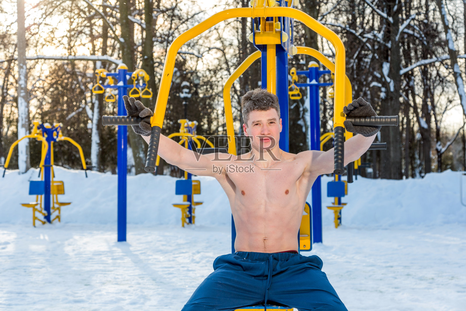 一个年轻人在公园的健身器材前做运动照片摄影图片