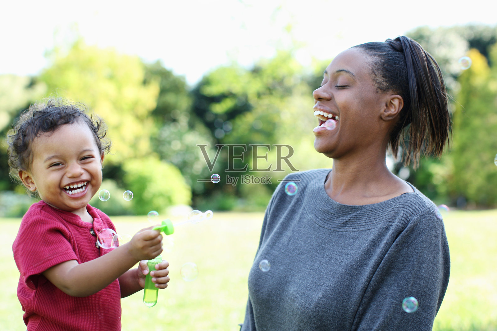 母亲和儿子吹泡泡照片摄影图片