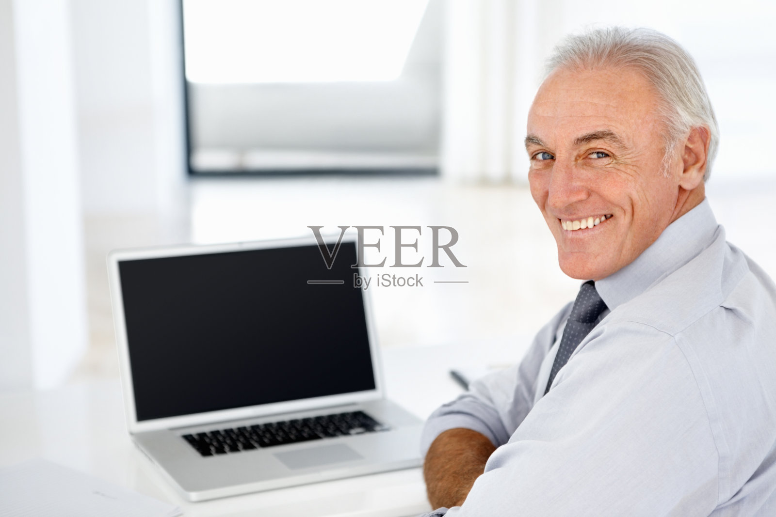 微笑着拿着笔记本电脑的男性高管照片摄影图片