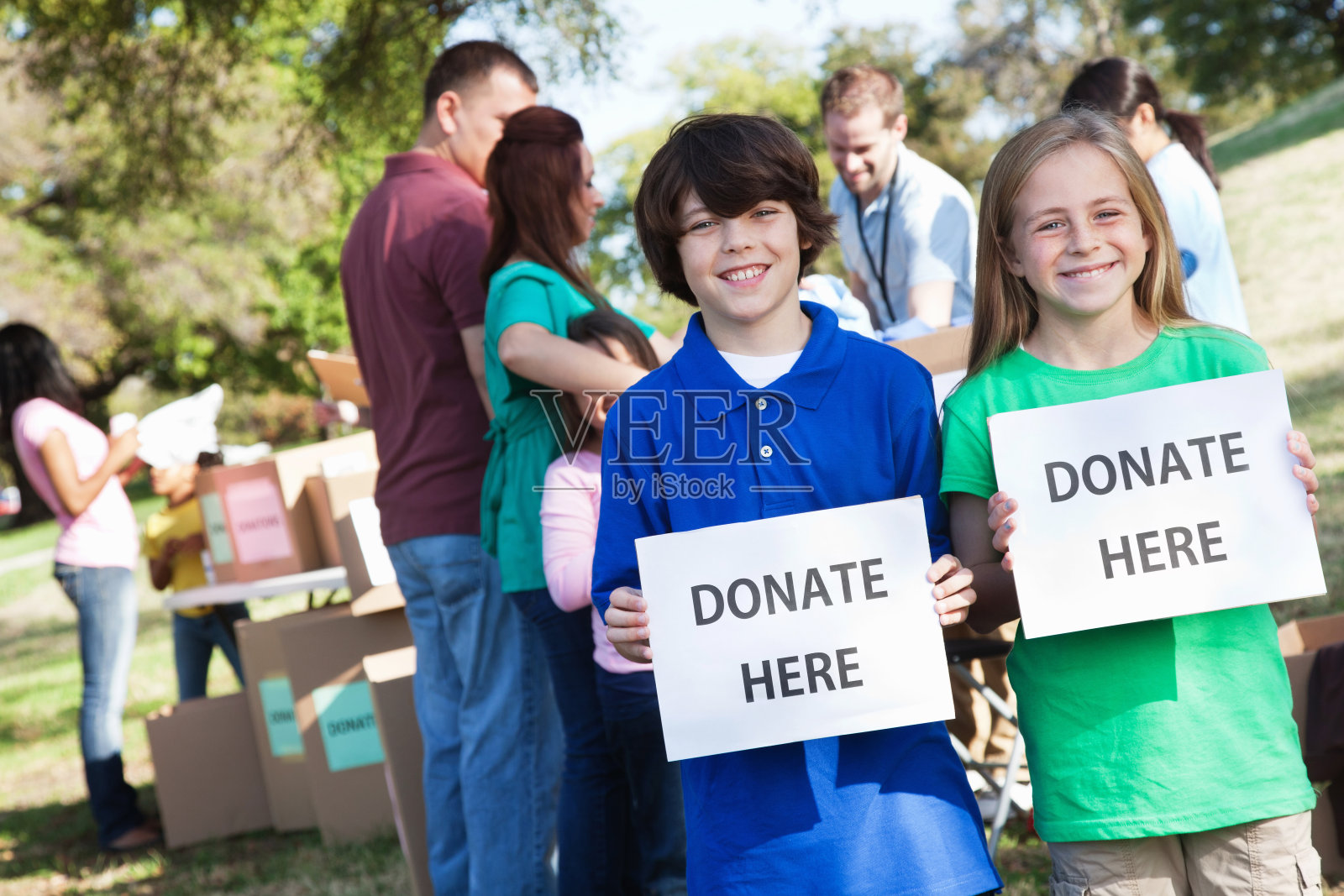在捐赠中心,快乐的孩子们举着捐赠标志照片摄影图片