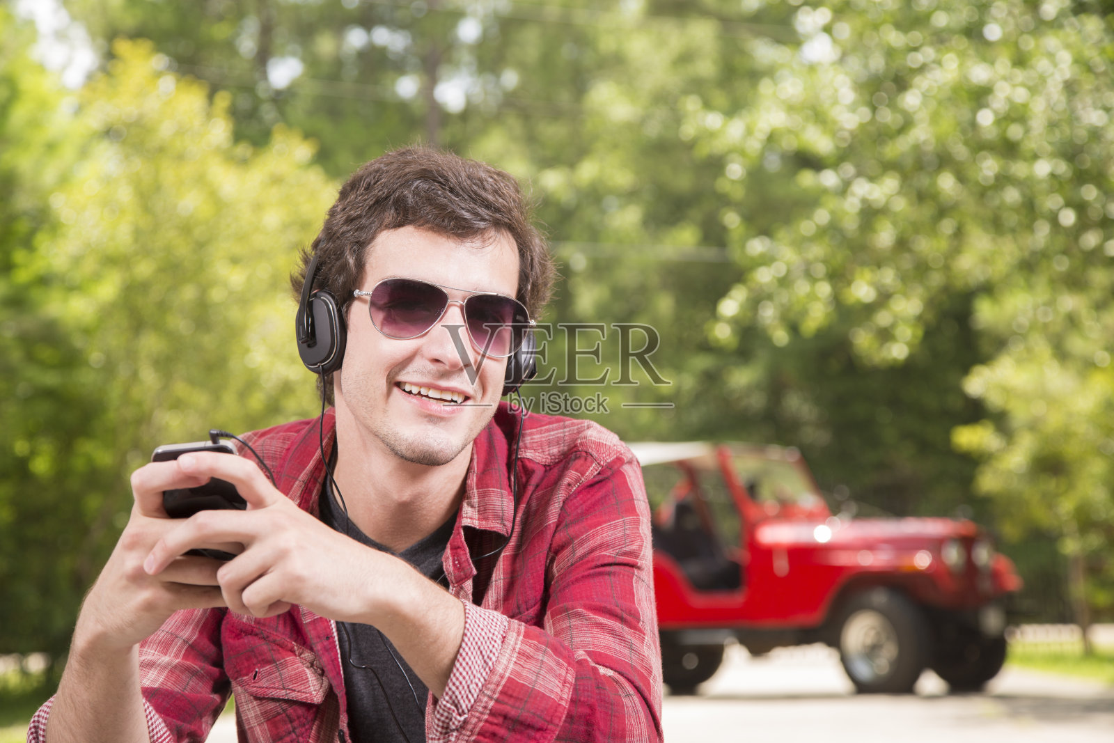 科技:年轻人戴着耳机听音乐。照片摄影图片