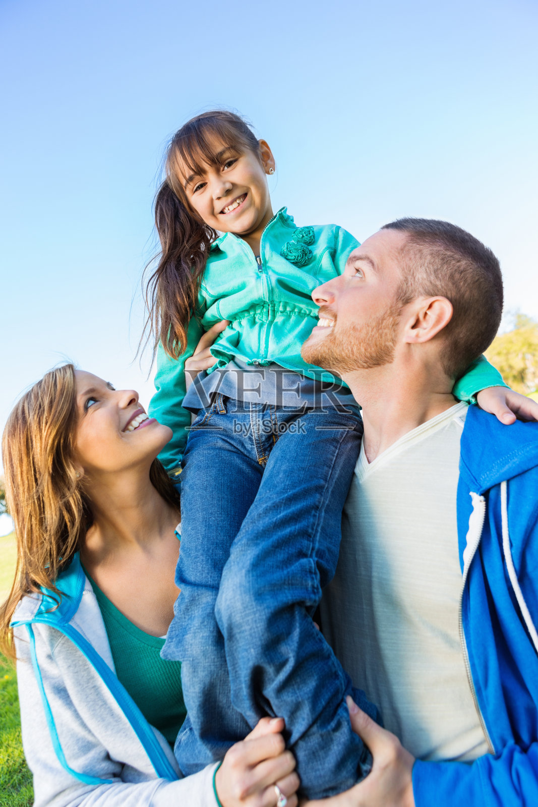 在户外,父母把小女儿扛在肩上照片摄影图片