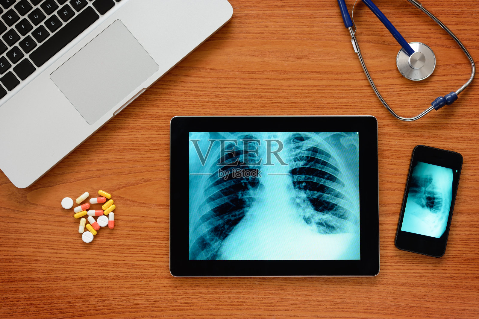 笔记本电脑,智能手机和平板电脑在医生的桌子上照片摄影图片