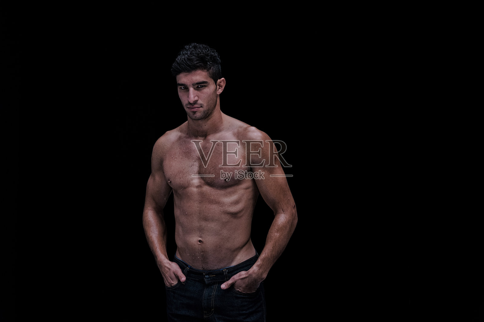 赤裸上身的肌肉男在黑色背景前照片摄影图片