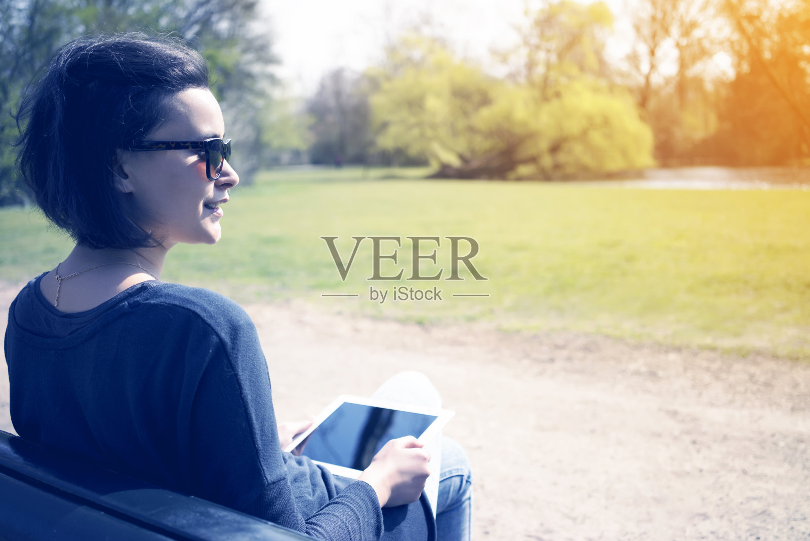 年轻女子在户外使用平板电脑照片摄影图片