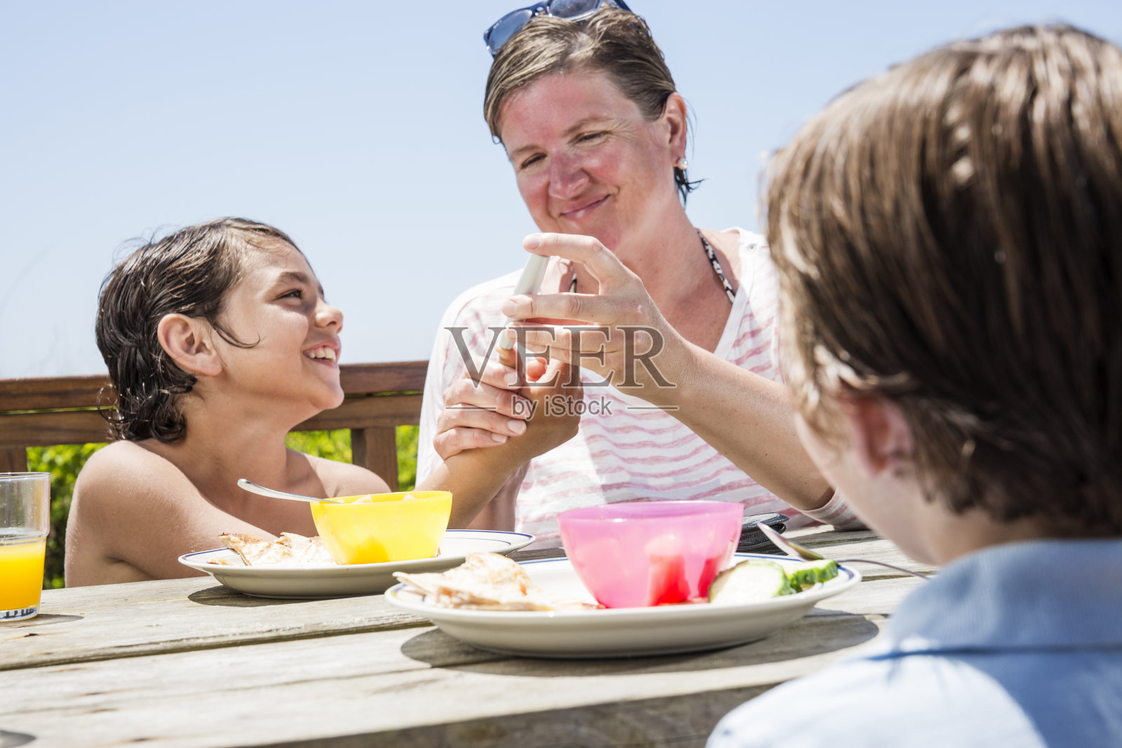 母亲在检查儿子的血糖水平照片摄影图片