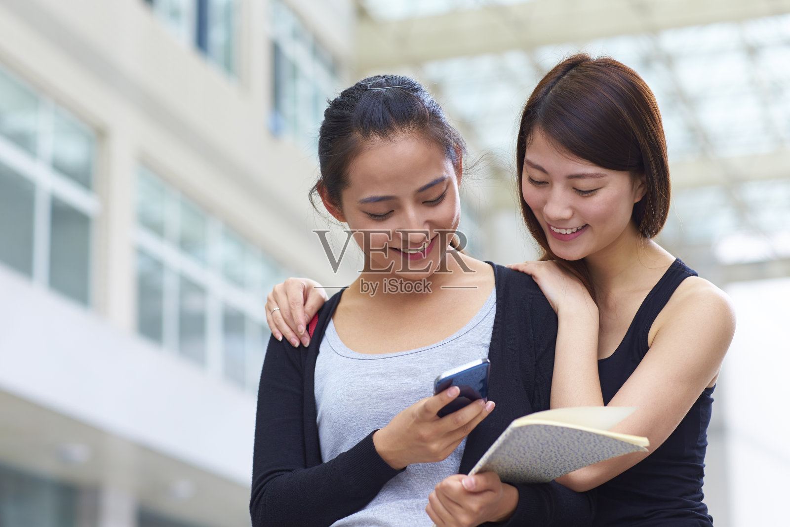 两个朋友在手机上分享信息照片摄影图片