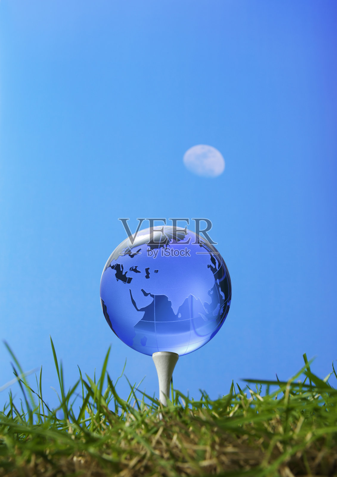 草地和正午月亮上的玻璃地球照片摄影图片