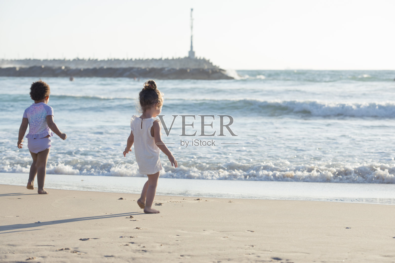 两个小女孩在海滩上。照片摄影图片