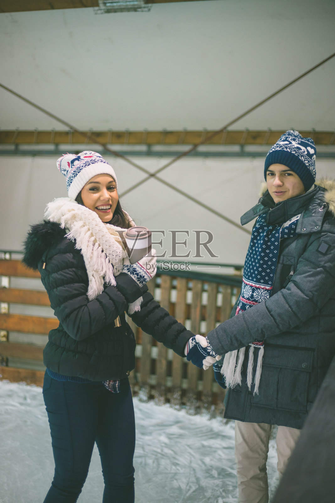 人们,冬天,友谊,运动和休闲概念-快乐的朋友在户外溜冰场滑冰照片摄影图片