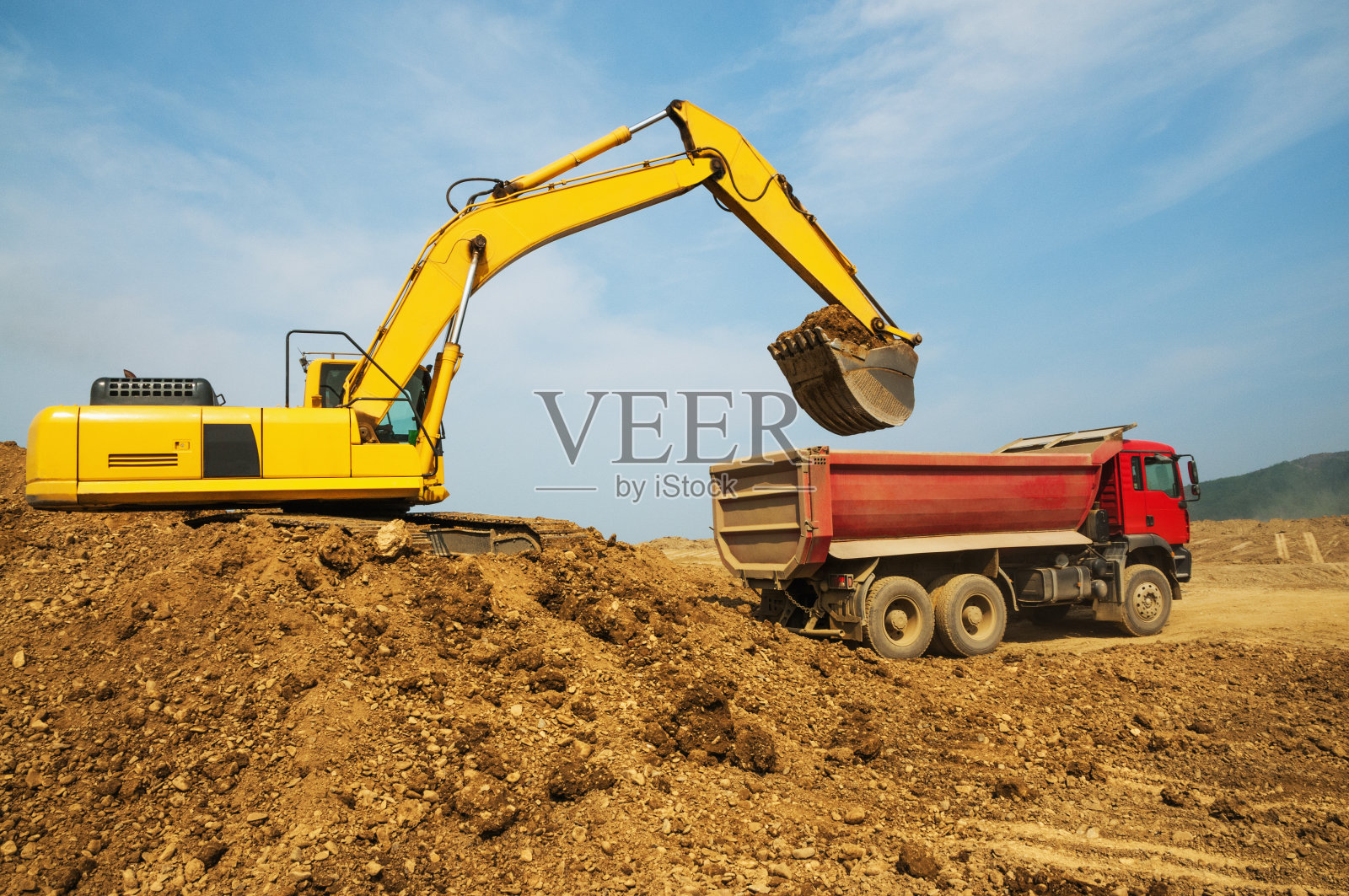 土方工程。把泥土装进自卸货车的车体。照片摄影图片