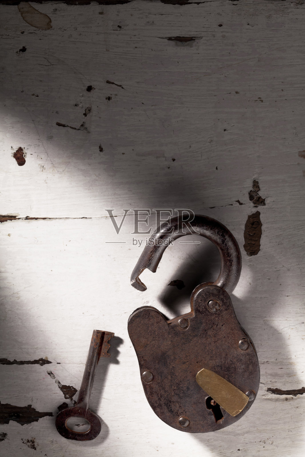 旧锁和钥匙在一束光里。照片摄影图片