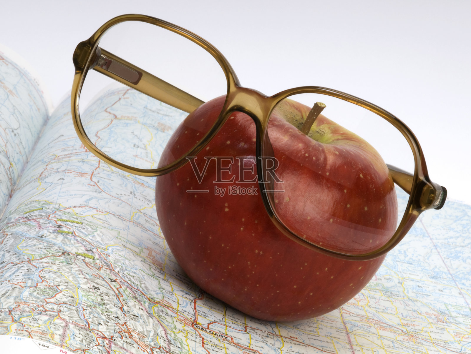 戴眼镜的大苹果在加拿大地图上照片摄影图片