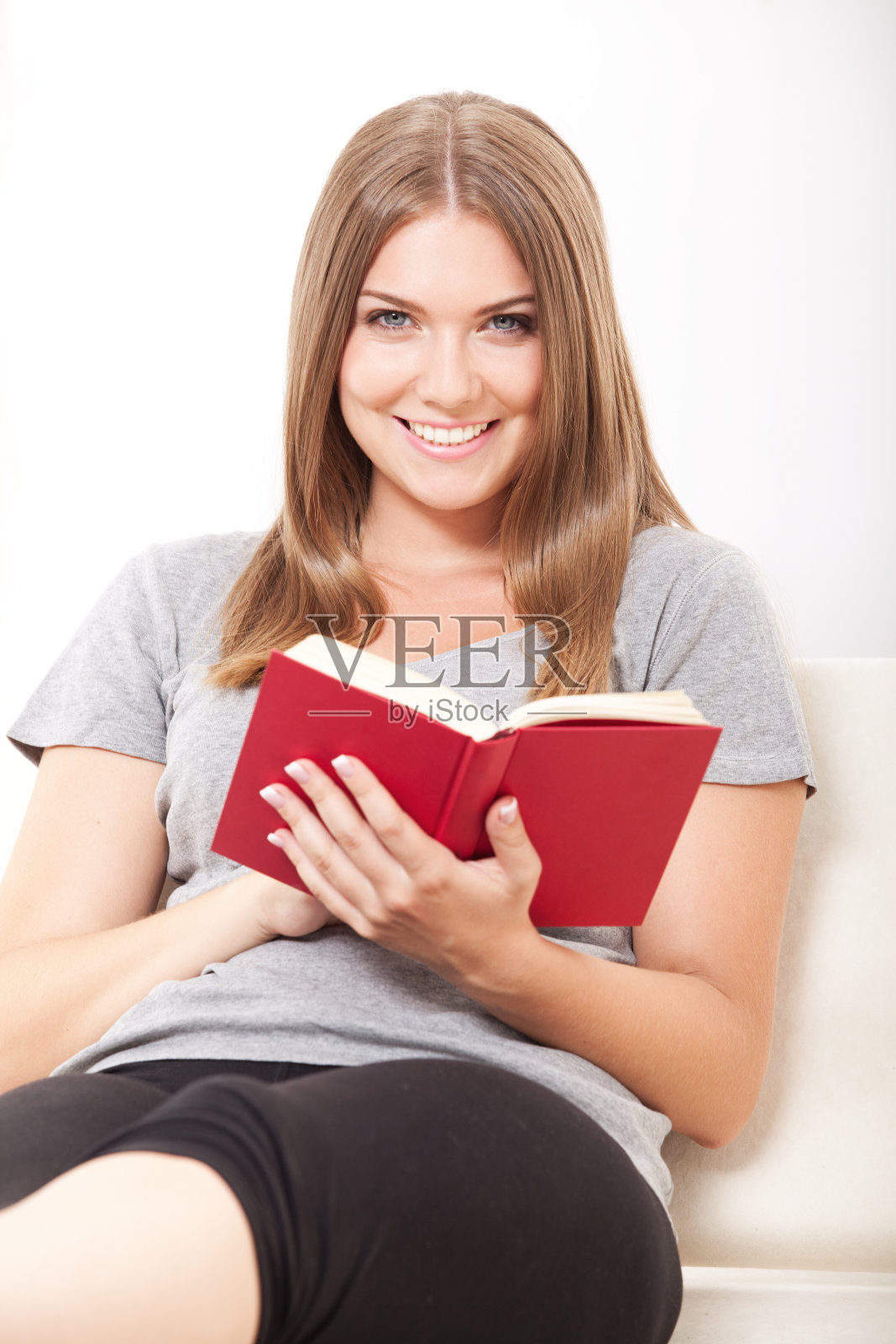 美丽的年轻女子在看书和微笑照片摄影图片