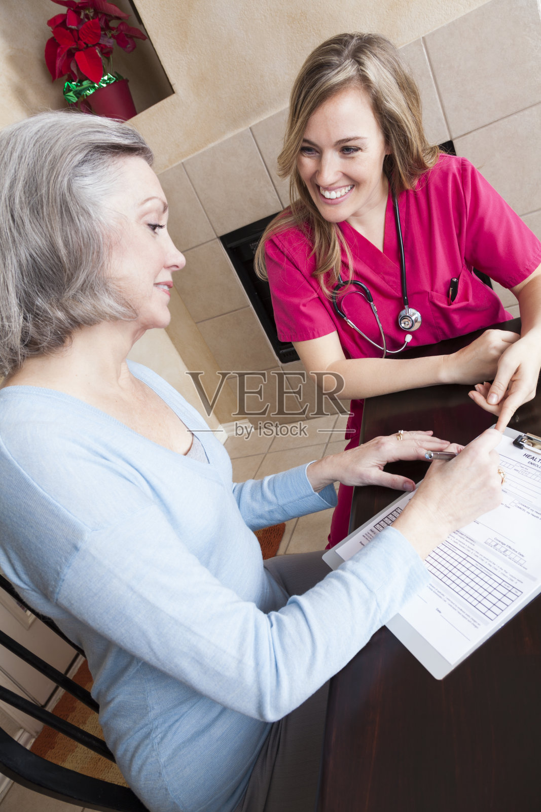 老年病人和家庭护理人员一起填写表格照片摄影图片