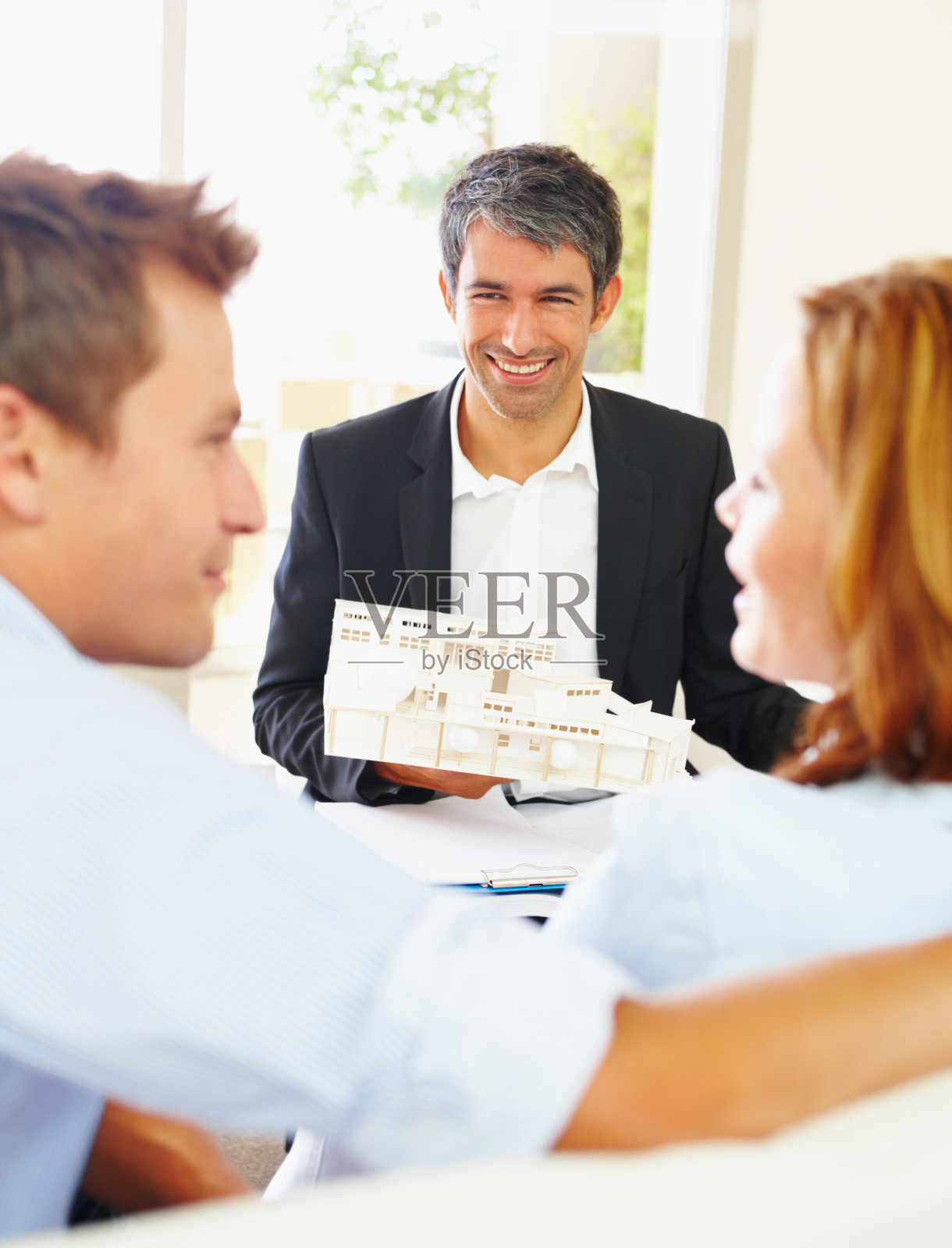 成功的建筑师与房子模型的年轻夫妇照片摄影图片