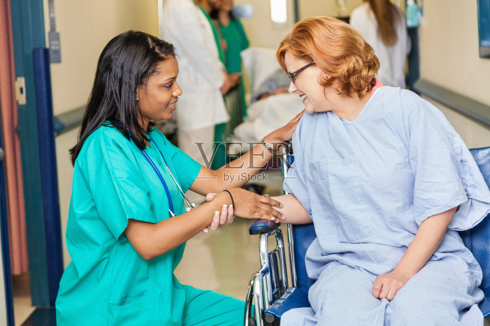 友善的护士在医院走廊协助女病人照片摄影图片