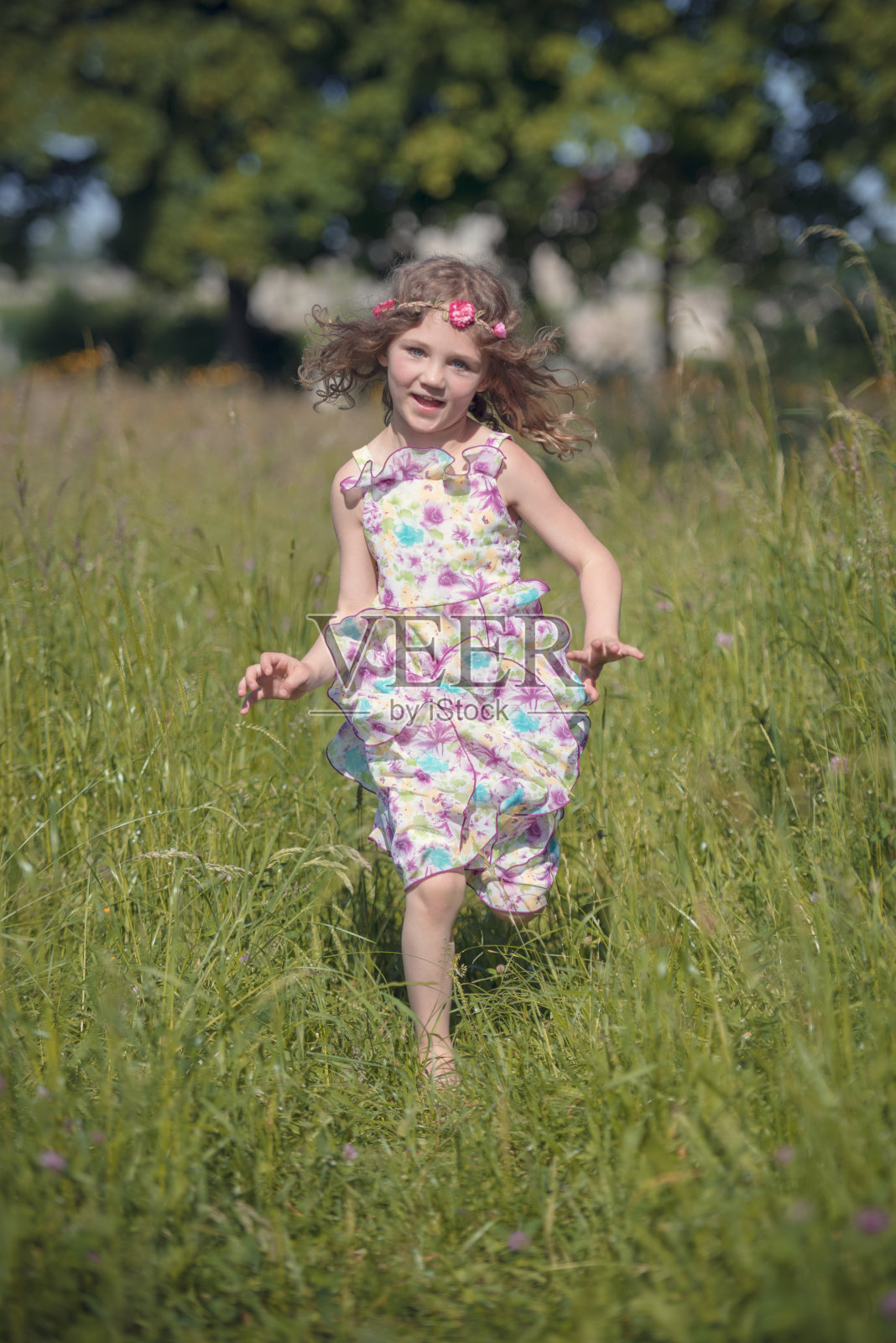 金发小女孩在花草地上奔跑照片摄影图片
