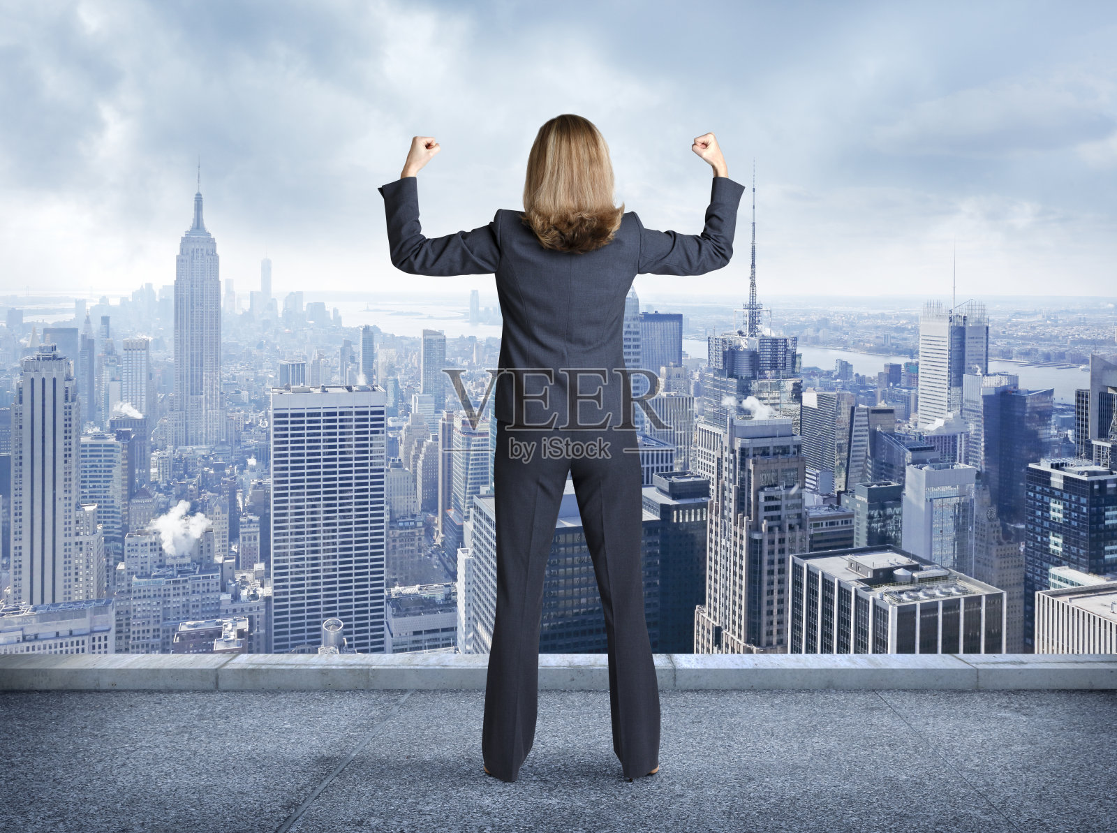 女商人一边展示着她的肌肉一边俯瞰着纽约市照片摄影图片