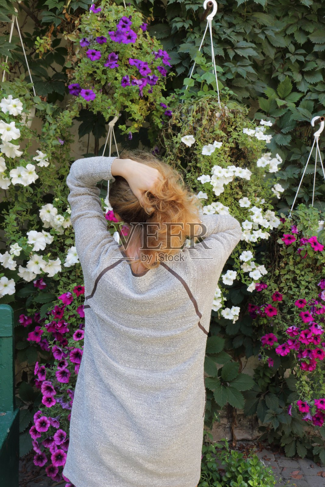 在花墙前的女人。照片摄影图片