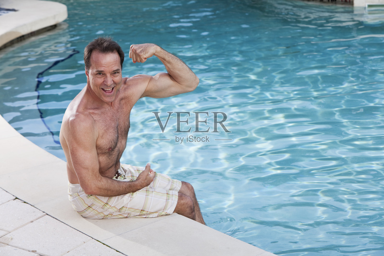 一个成熟的男人坐在泳池边照片摄影图片