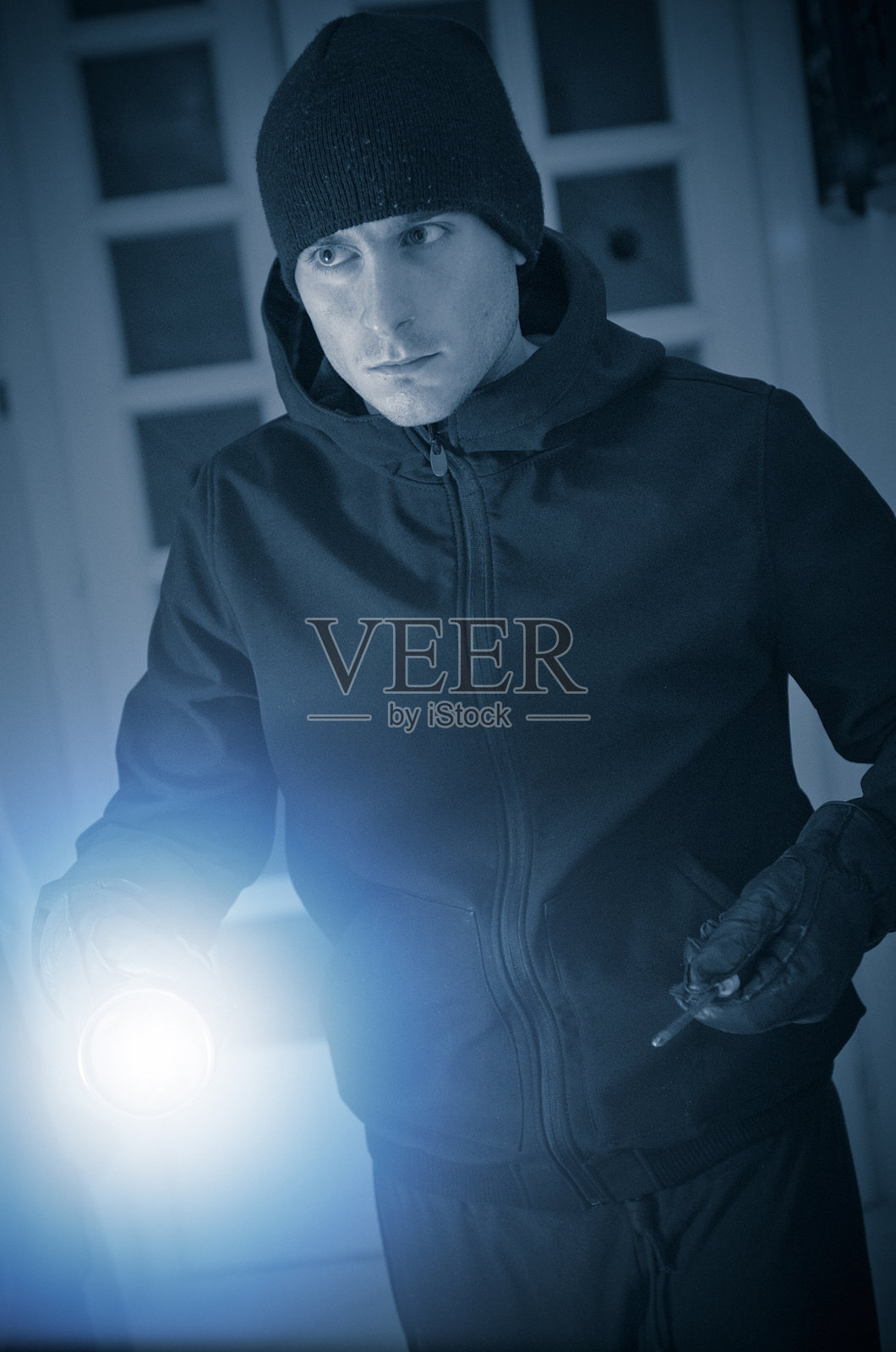 拿着手电筒的白人小偷照片摄影图片