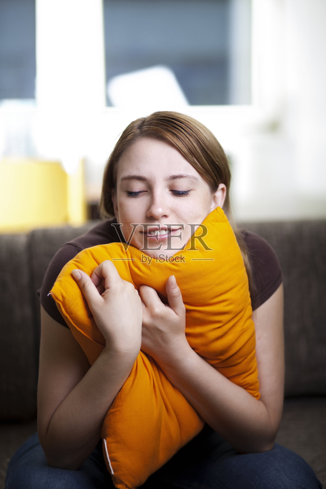 抱着枕头的年轻女子照片摄影图片