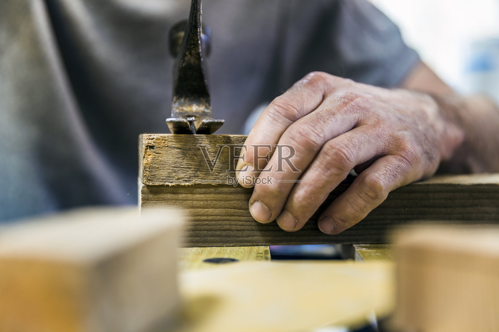 用锤子把钉子从木头上拆下来的木匠照片摄影图片