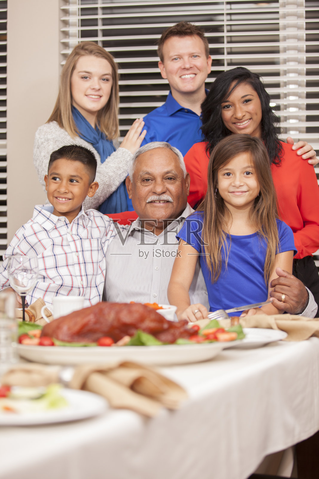 多民族,一代又一代家庭享用感恩节大餐。照片摄影图片