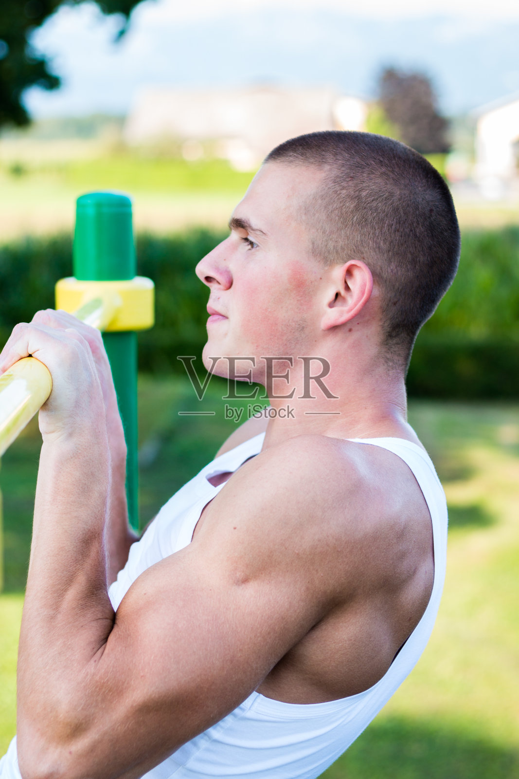 一个年轻人在户外单杠上做引体向上照片摄影图片