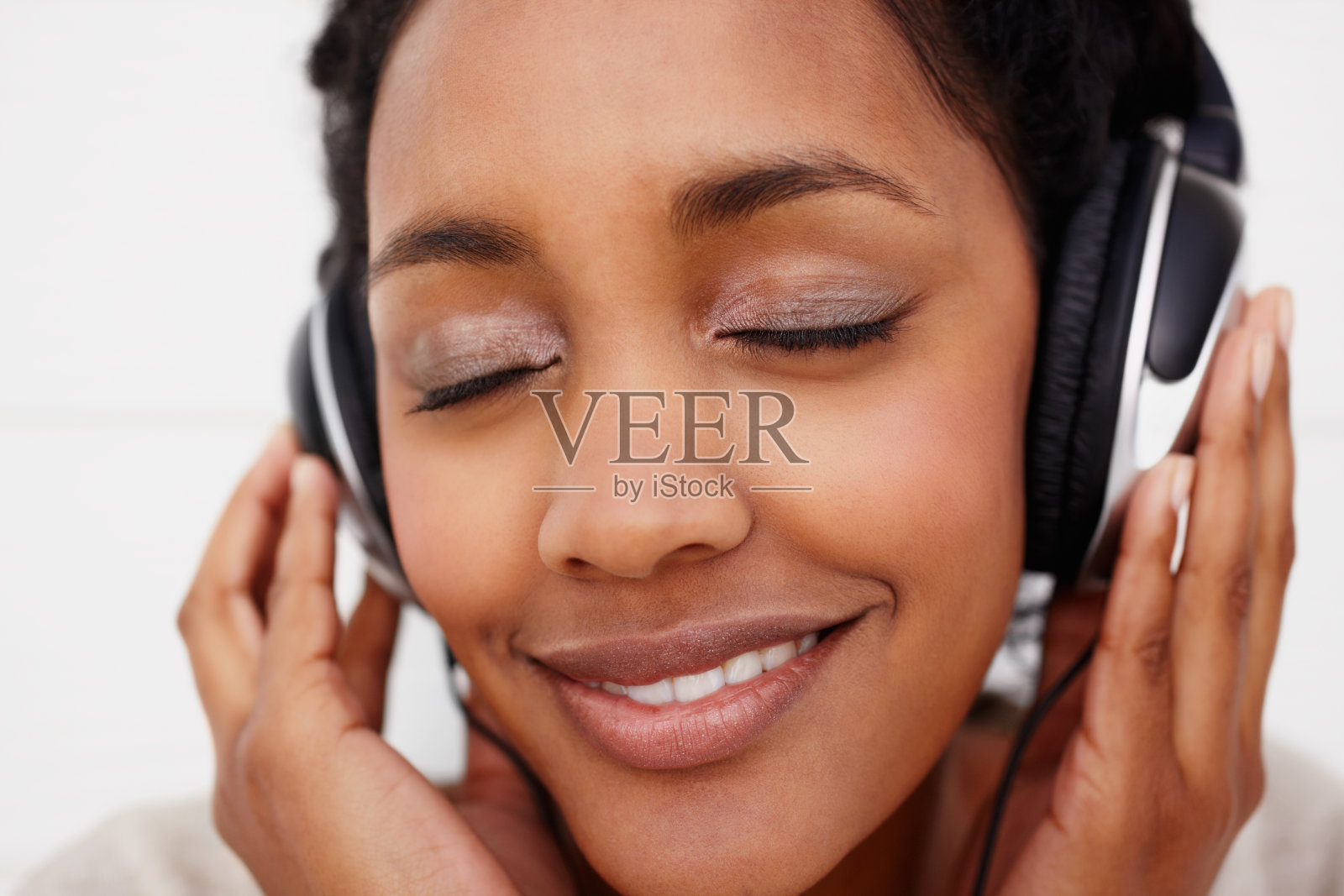 一个非洲女性听着悦耳的音乐的特写照片摄影图片