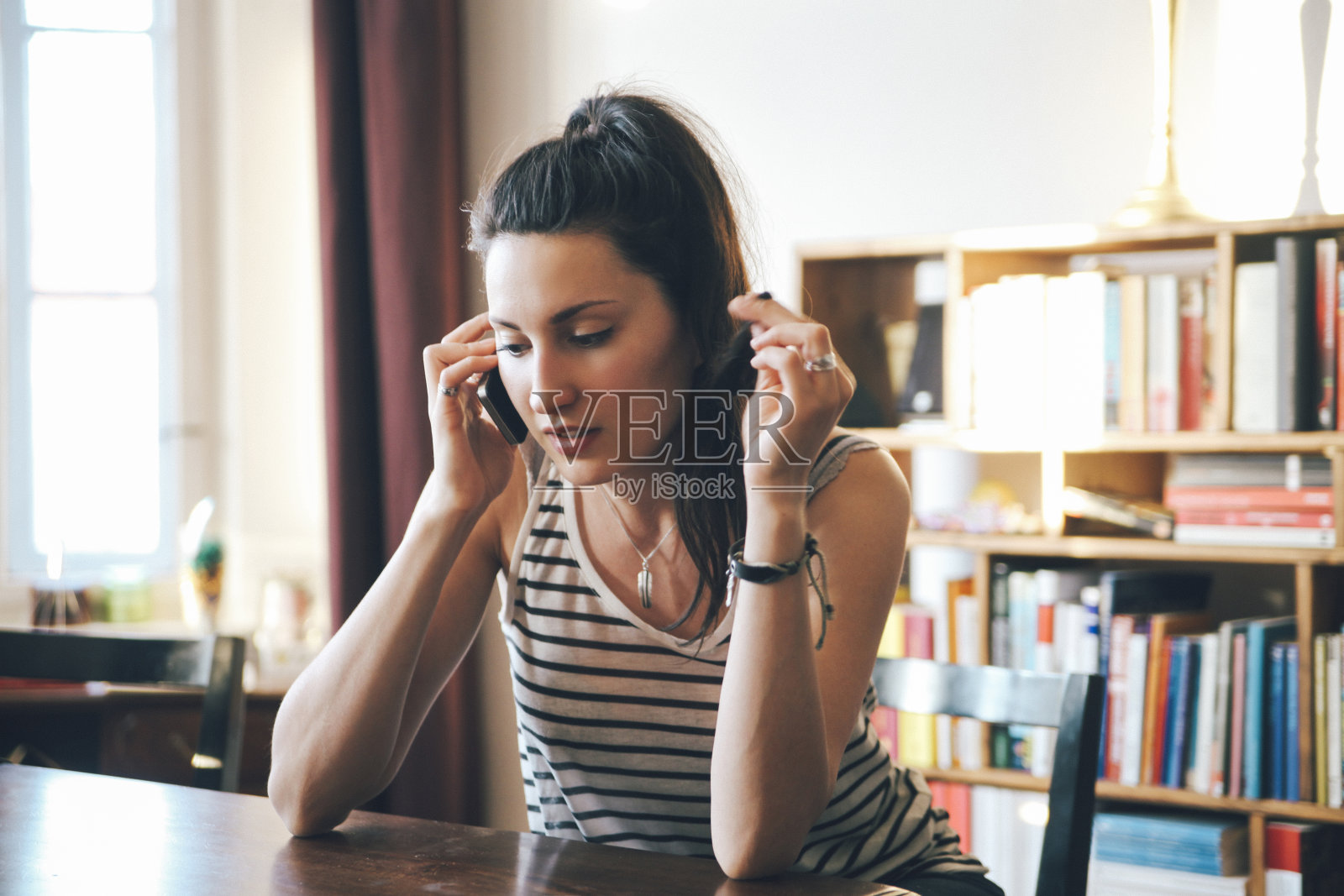 年轻女子在家里打电话照片摄影图片