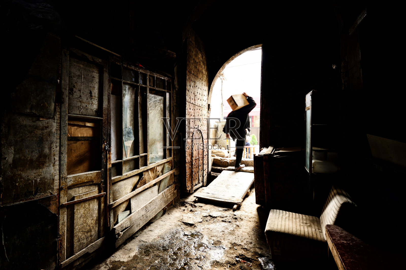 一个男人从旧仓库搬来一个箱子照片摄影图片