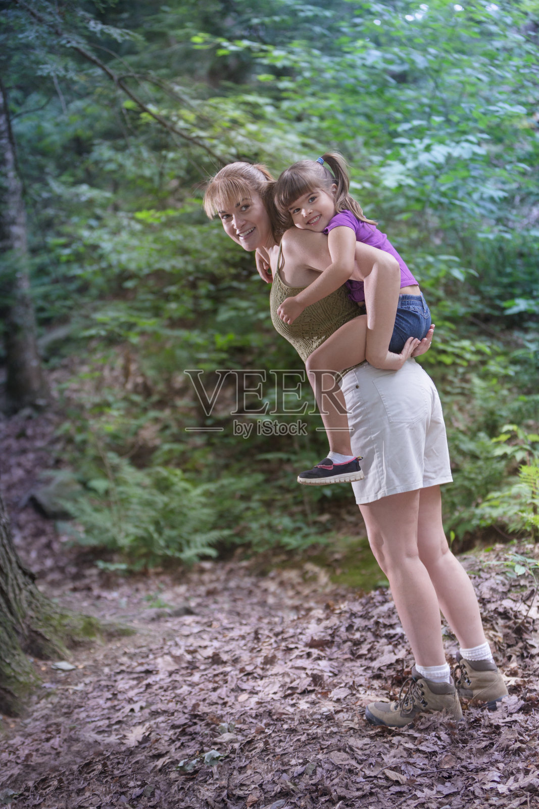 母亲和女儿在森林里探险照片摄影图片