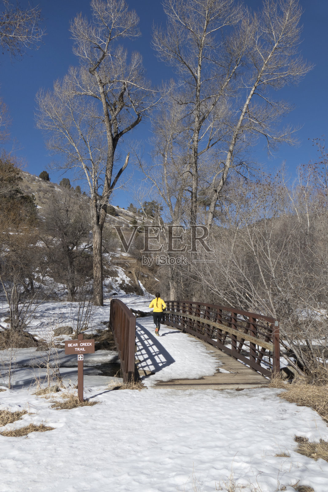 一名年轻女子在科罗拉多落基山脉雪地里奔跑照片摄影图片