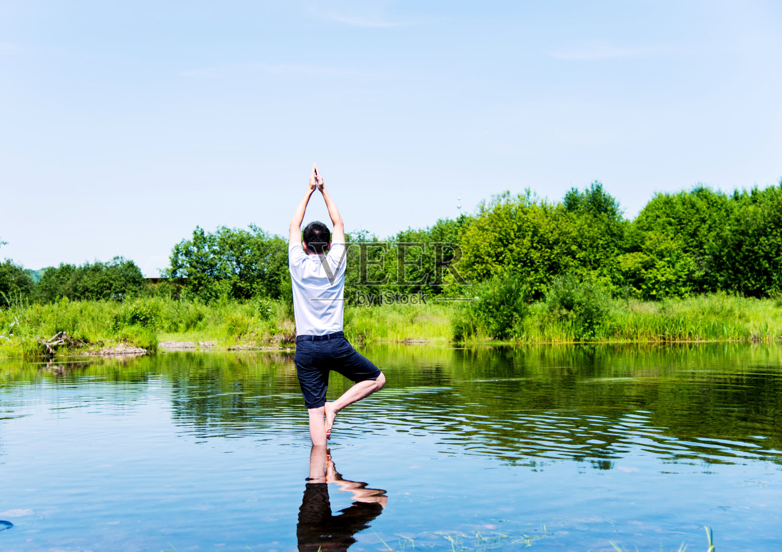 树上的人在岩石上做瑜伽照片摄影图片