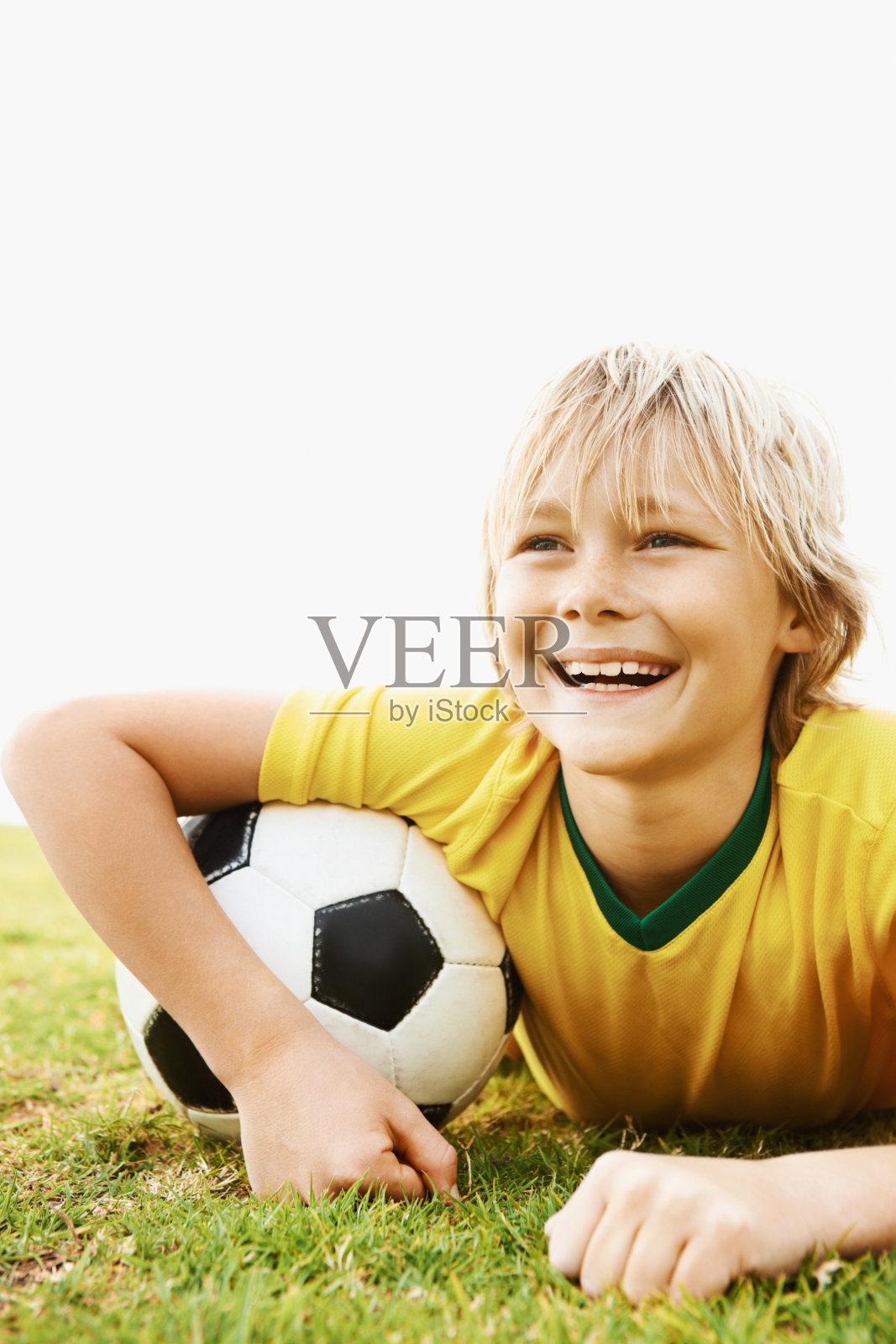 年轻的足球运动员躺在球场上微笑着照片摄影图片