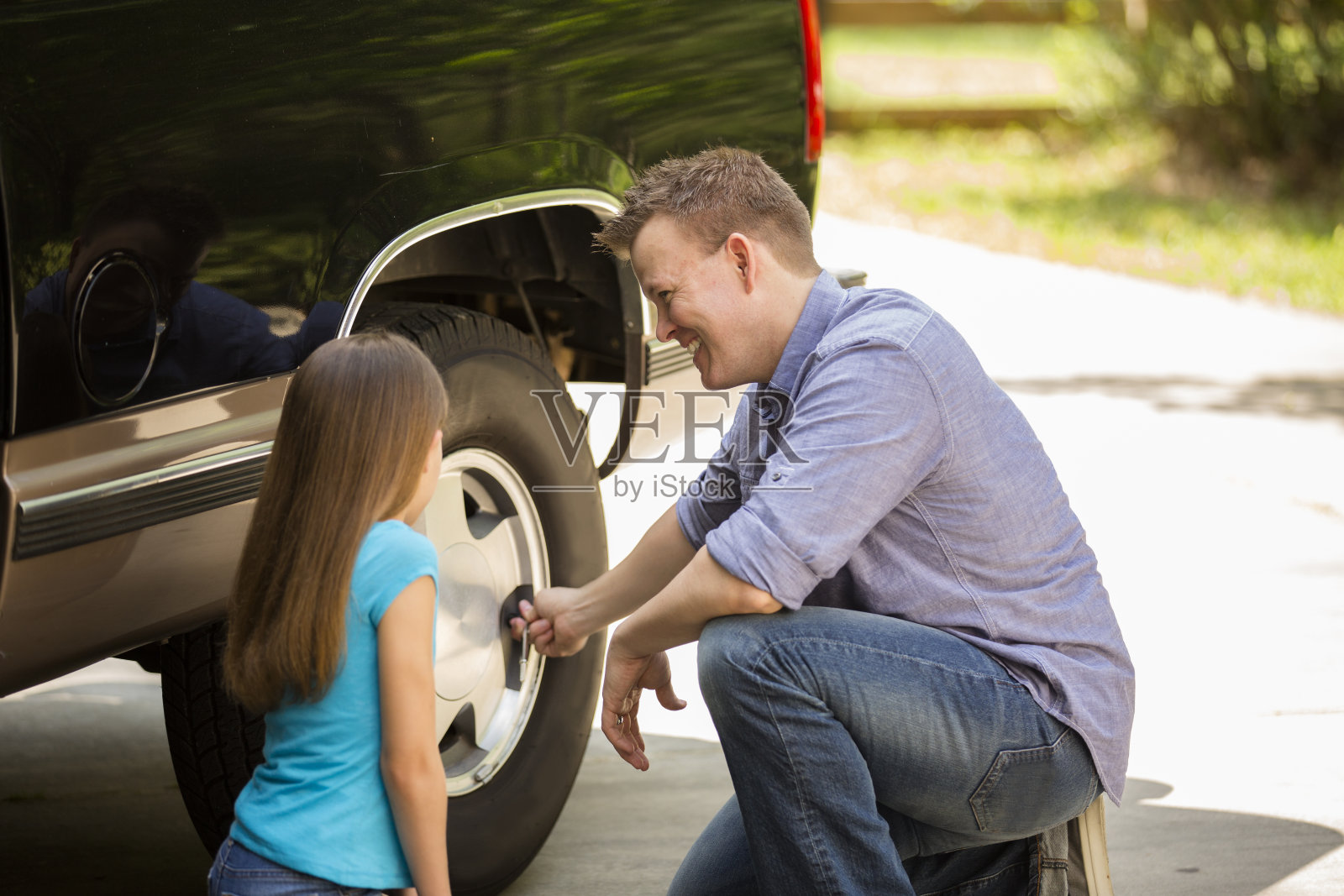 女儿向父亲学习。爸爸,孩子拿着工具,修着车。照片摄影图片