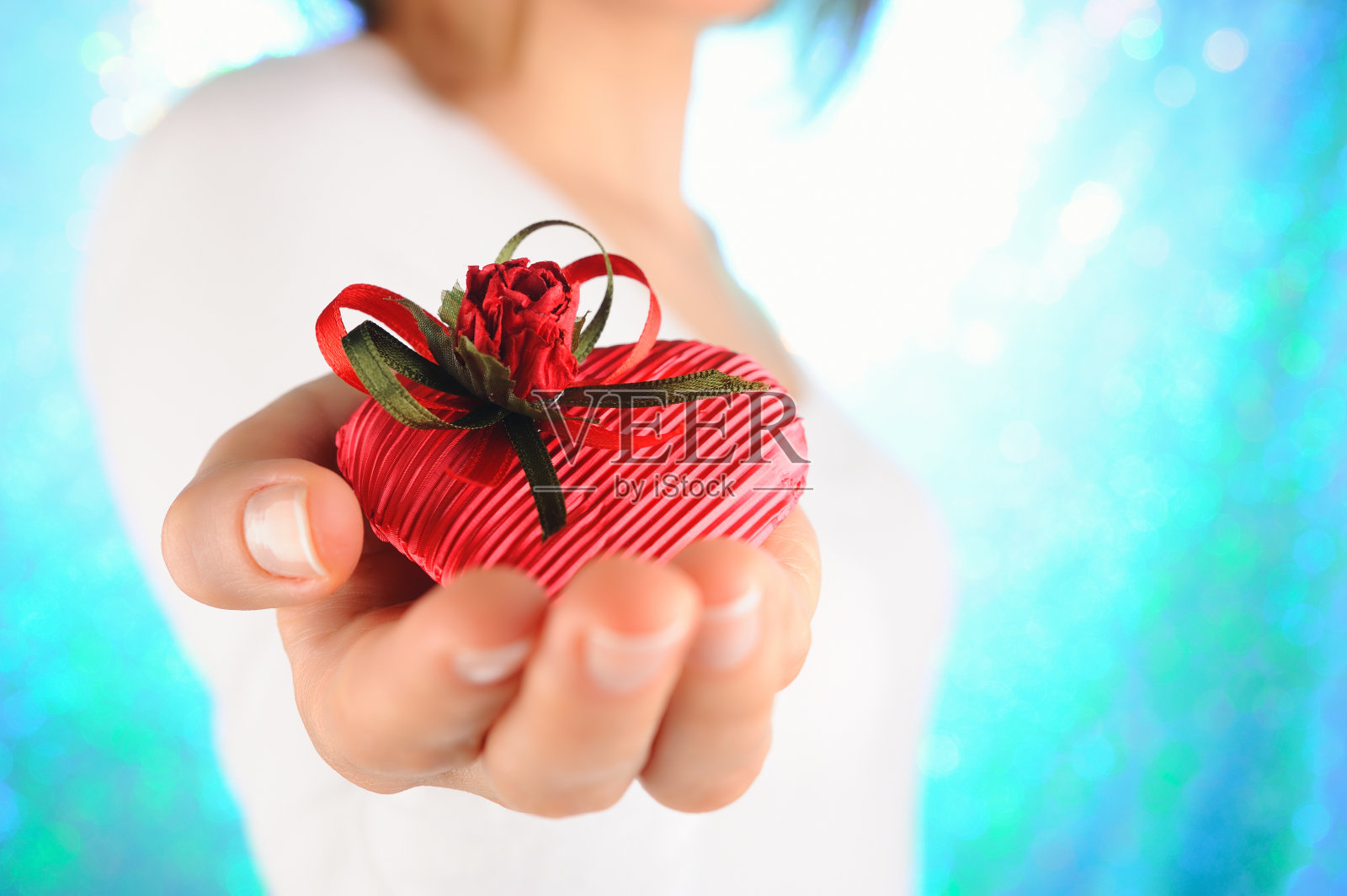 年轻女子拿着一个红色的心型礼物照片摄影图片