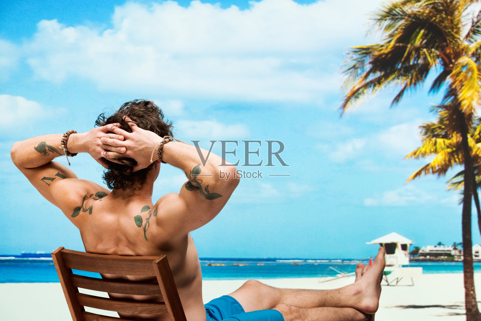 后视图赤膊男子坐在沙滩椅上照片摄影图片