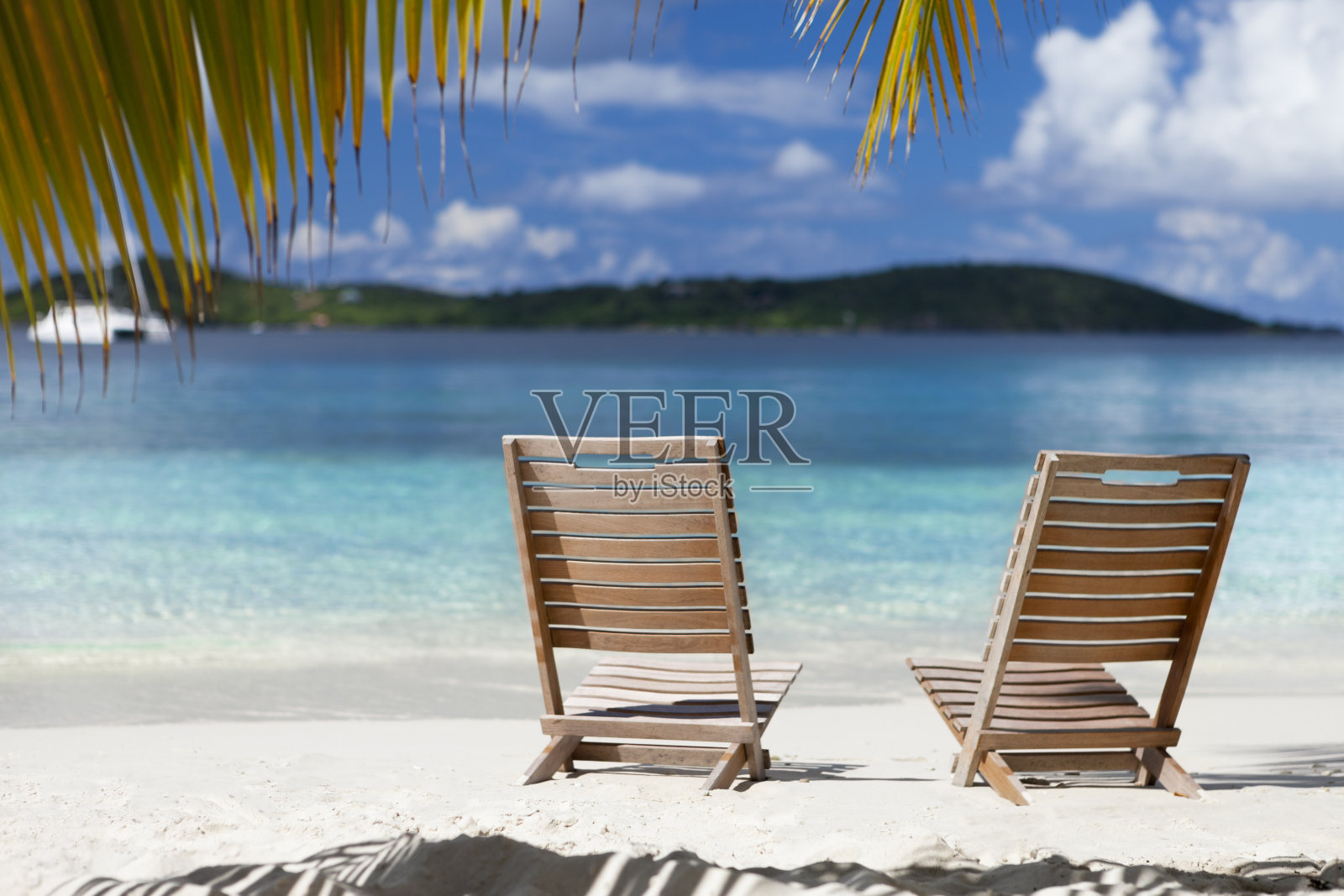 椅子在加勒比海滩的一棵棕榈树下照片摄影图片