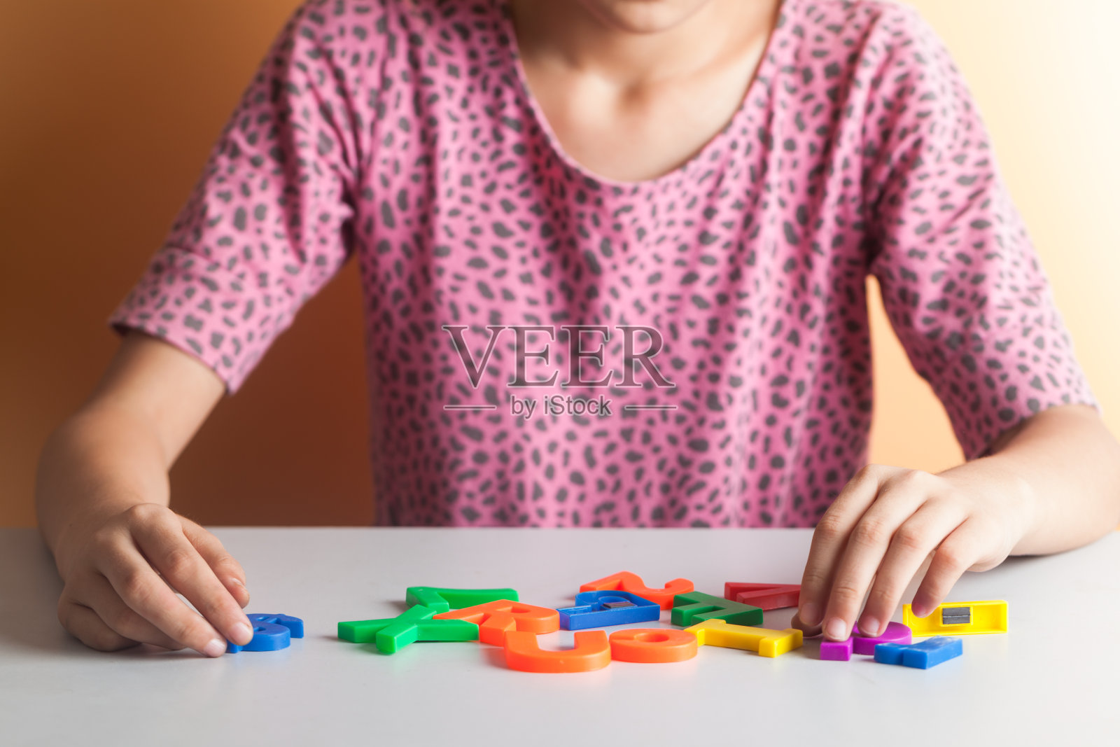 亚洲女孩坐在桌子前玩数字游戏照片摄影图片