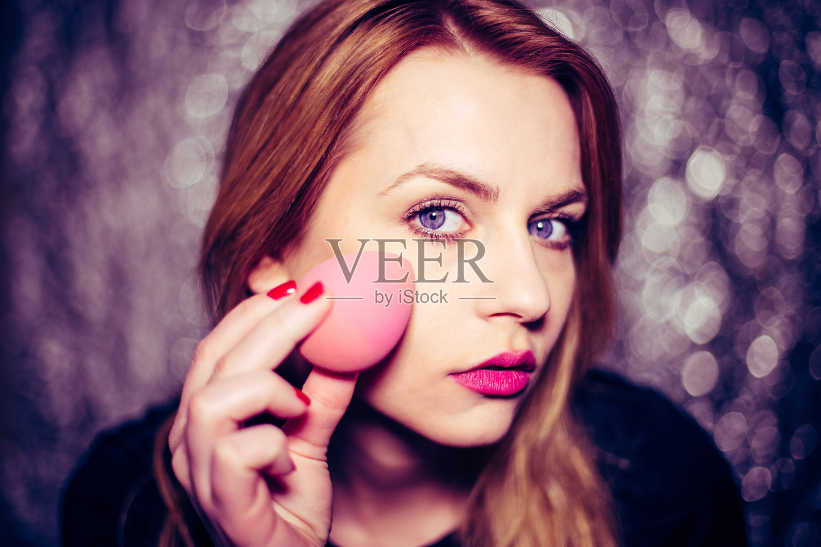 漂亮的女孩正在用化妆海绵化妆照片摄影图片