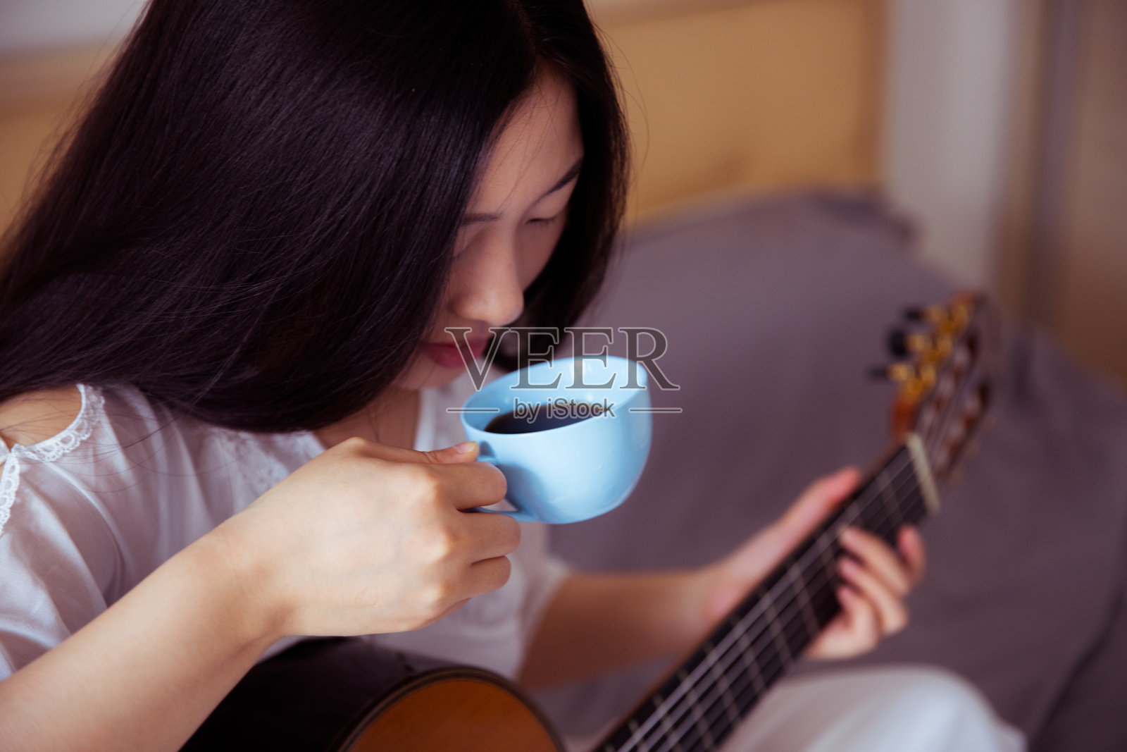 拿着咖啡杯和吉他的女人照片摄影图片